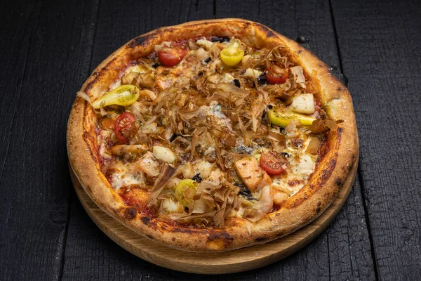 stock image tasty pizza with cheese and vegetables on a wooden dark table