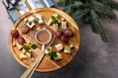 Peynir tabağı: Camembert, Parmesan peyniri, fındık, bal ve üzümlü mavi peynir.