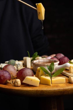 Peynir tabağı: Camembert, Parmesan peyniri, fındık, bal ve üzümlü mavi peynir.