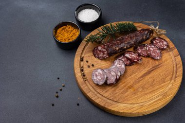 Geleneksel et lezzetleri, karanlık bir masada sosisler.