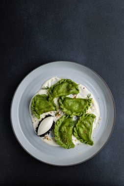 delicious Ukrainian dumplings with sauce on a plate.