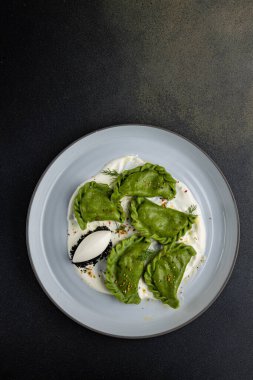 delicious Ukrainian dumplings with sauce on a plate.