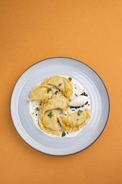 delicious Ukrainian dumplings with sauce on a plate.