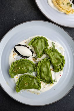 delicious Ukrainian dumplings with sauce on a plate.