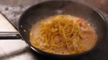 the chef prepares seafood pasta