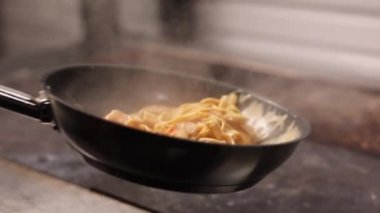 the chef prepares seafood pasta