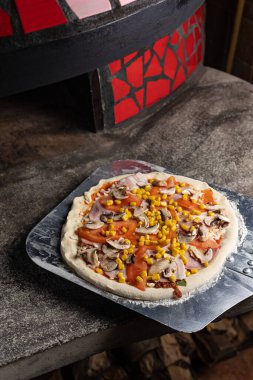 Şef restoranda lezzetli bir pizza hazırlar. Yakın plan.