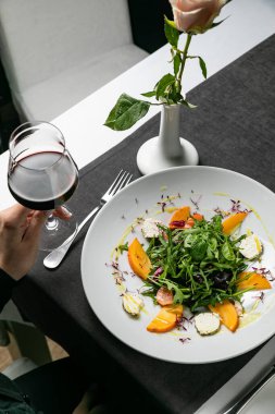 Delicious salad with figs arugula and goat cheese on white plate top view