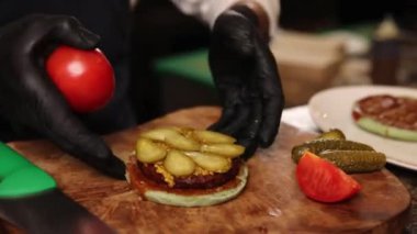 the chef prepares a delicious hamburger from a vegan patty