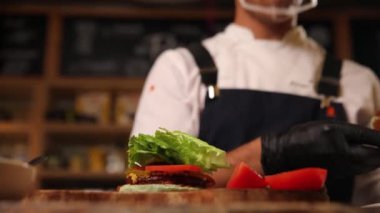 the chef prepares a delicious hamburger from a vegan patty