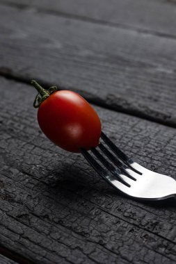 Üzerinde domates olan siyah bir çatal..