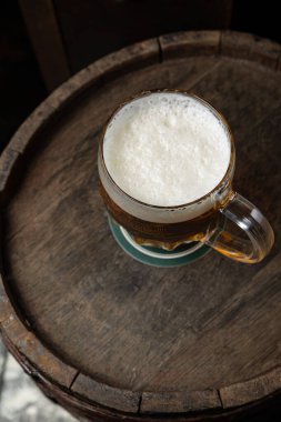 Bardaktaki bira bir restoranda bira fıçısının üzerinde duruyor.