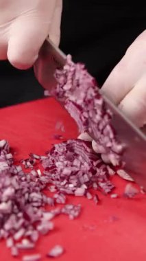 Şef kırmızı tahtada soğan doğruyor.