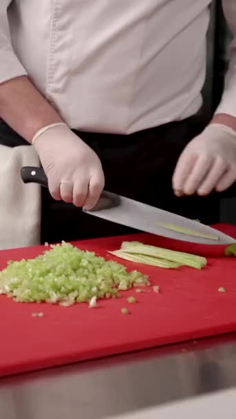 Koki Memotong Seledri Pada Papan Potong Merah — Stok Video