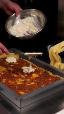 Şef mutfakta lazanya hazırlıyor.