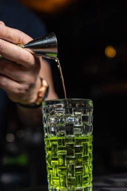 Alkol barda kokteyl. Barmen bir alkollü kokteyl hazırlar. Lezzetli içecek