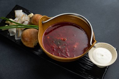 Tahtada iki parça ekmek olan bir kase çorba..