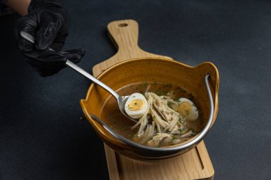 Tahtada iki parça ekmek olan bir kase çorba..