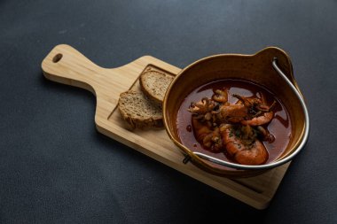 Tahtada iki parça ekmek olan bir kase çorba..