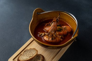 Tahtada iki parça ekmek olan bir kase çorba..