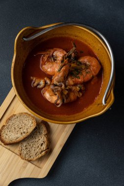 Tahtada iki parça ekmek olan bir kase çorba..