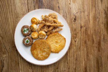 Bir tabak kızarmış et, kızarmış tavuk ve kızarmış patates..