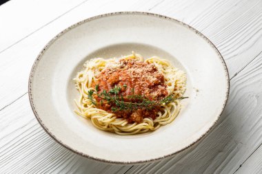 Beyaz ahşap bir masada tabakta lezzetli bir makarna. yakın plan