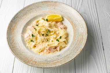 Beyaz ahşap bir masada tabakta lezzetli bir makarna. yakın plan