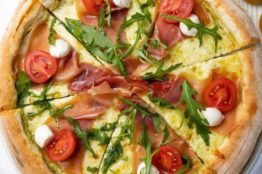 Beyaz ahşap bir masada lezzetli bir pizza. yakın plan