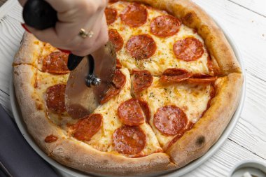 Beyaz ahşap bir masada lezzetli bir pizza. yakın plan