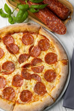 Beyaz ahşap bir masada lezzetli bir pizza. yakın plan