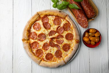 Beyaz ahşap bir masada lezzetli bir pizza. yakın plan