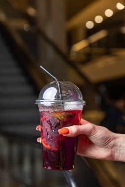 Bir bardak kırmızı çay ve ahşap masada bir kokteyl.