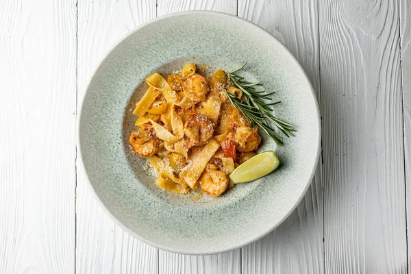 Stock image delicious pasta in a plate on a white wooden table. close-up