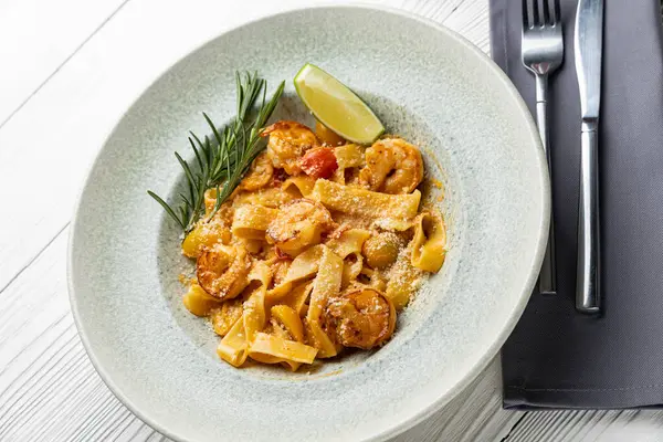 stock image delicious pasta in a plate on a white wooden table. close-up