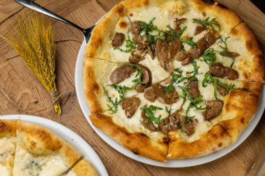 Tahta bir masada nefis İtalyan pizzası.