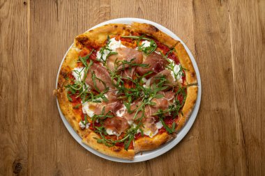 Tahta bir masada nefis İtalyan pizzası.