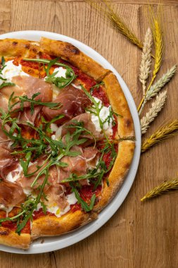 Tahta bir masada nefis İtalyan pizzası.