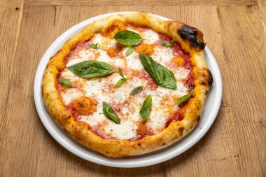 Tahta bir masada nefis İtalyan pizzası.