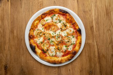 Tahta bir masada nefis İtalyan pizzası.