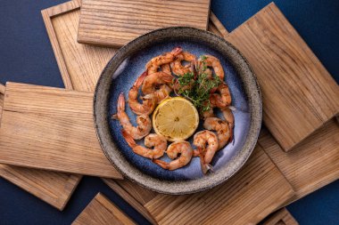 Yanında limon olan bir kase karides.