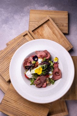 Bir parça et ve peynirli salata.