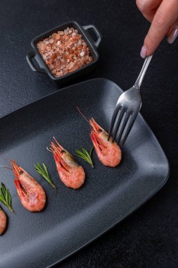 Siyah tabakta bir tabak karides.