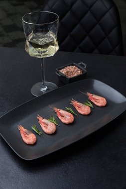 Siyah tabakta bir tabak karides.