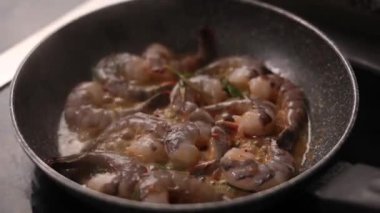 Bir şef karidesli yemek pişirir.