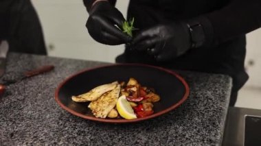 Kız aşçıyı yer ve lezzetli bir balık yemeği hazırlar. Yakın plan.