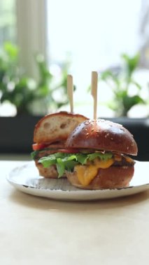 Bir kız hamburger yiyor. Yakın plan.