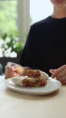 Bir kız shawarma yiyor. Yakın plan.