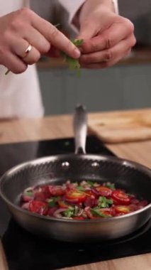 Şef mutfakta domatesli lezzetli bir yemek hazırlıyor. Yakın plan.