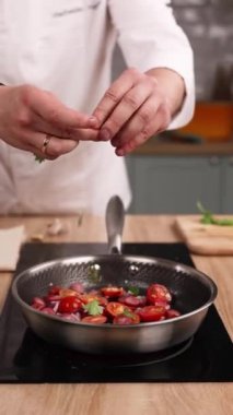 Şef mutfakta domatesli lezzetli bir yemek hazırlıyor. Yakın plan.